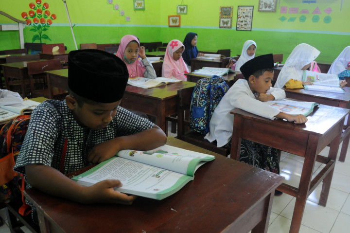 Sejumlah siswa sambil menggunakan busana muslim mengikuti Proses Belajar Mengajar di SDN Gladak Anyar 2, Pamekasan, Jawa Timur. ANTARA Foto/Saiful Bahri