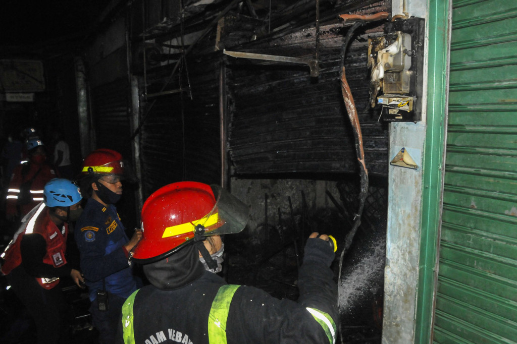 Petugas Pemadam Kebakaran (Damkar) melakukan proses pendinginan usai kebakaran di Pasar Tambun, Kabupaten Bekasi, Jawa Barat.