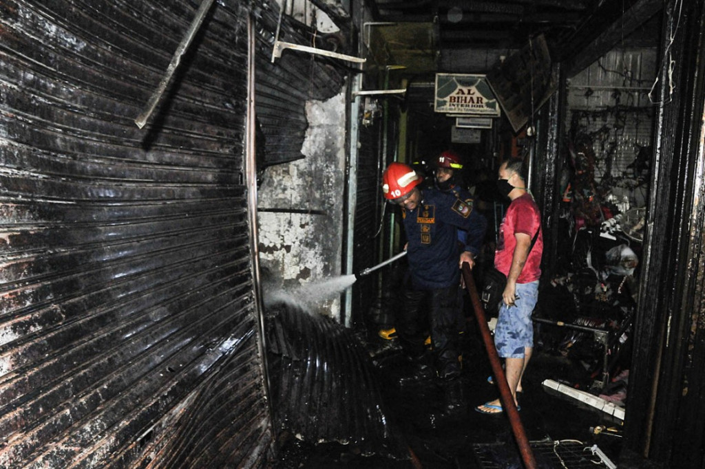 Petugas Pemadam Kebakaran (Damkar) melakukan proses pendinginan usai kebakaran di Pasar Tambun, Kabupaten Bekasi, Jawa Barat, Sabtu, 24 Oktober 2020.
