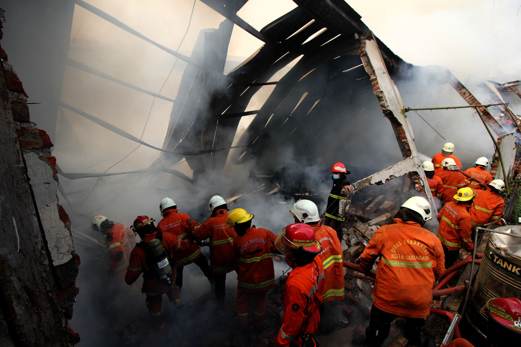 Petugas Dinas Pemadam Kebakaran Kota Surabaya melakukan pembasahan gudang yang terbakar di Jalan Simorejo Sari B, Surabaya, Jawa Timur, Selasa, 27 Oktober 2020.