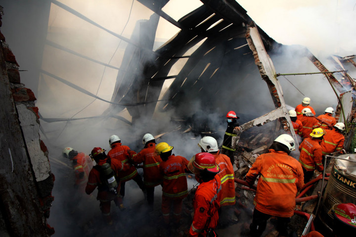 Petugas Dinas Pemadam Kebakaran Kota Surabaya melakukan pembasahan gudang yang terbakar di Jalan Simorejo Sari B, Surabaya, Jawa Timur, Selasa, 27 Oktober 2020.