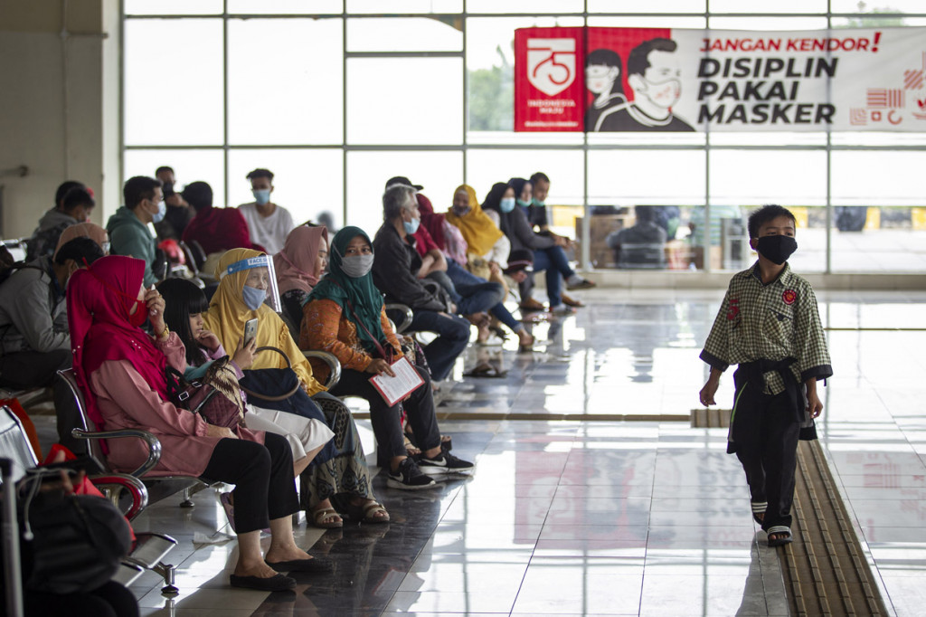 Calon penumpang menunggu jadwal keberangkatan bus di Terminal Terpadu Pulo Gebang, Jakarta.
