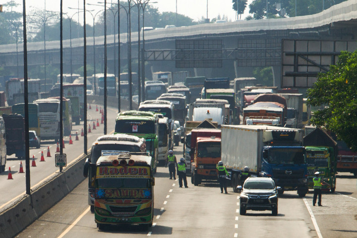 Petugas kepolisan mengatur lalu lintas kendaraan saat pemberlakuan rekayasa lalu lintas di jalan tol Jakarta - Cikampek (Japek) KM 47, Karawang, Jawa Barat. ANTARA Foto/Muhamad Ibnu Chazar 
