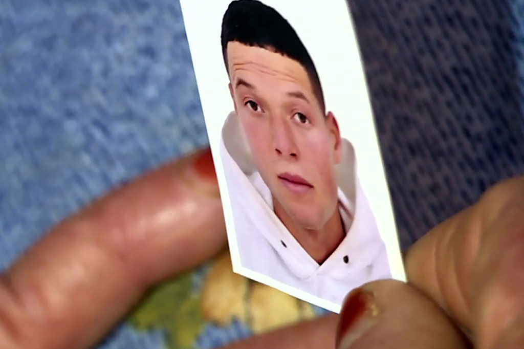 Gambar yang diambil dari AFPTV menunjukkan foto tersangka penyerang di Kota Nice, Prancis, Brahim Aouissaoui, tengah di pegang ibunya di rumah keluarga di Kota Sfax, Tunisia, Jumat, 30 Oktober 2020.