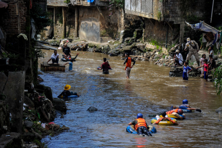Sejumlah warga bersama Komunitas Sungai Cikapundung menyusuri Sungai Cikapundung menggunakan ban karet di Tamansari, Bandung, Jawa Barat, Sabtu, 31 Oktober 2020.