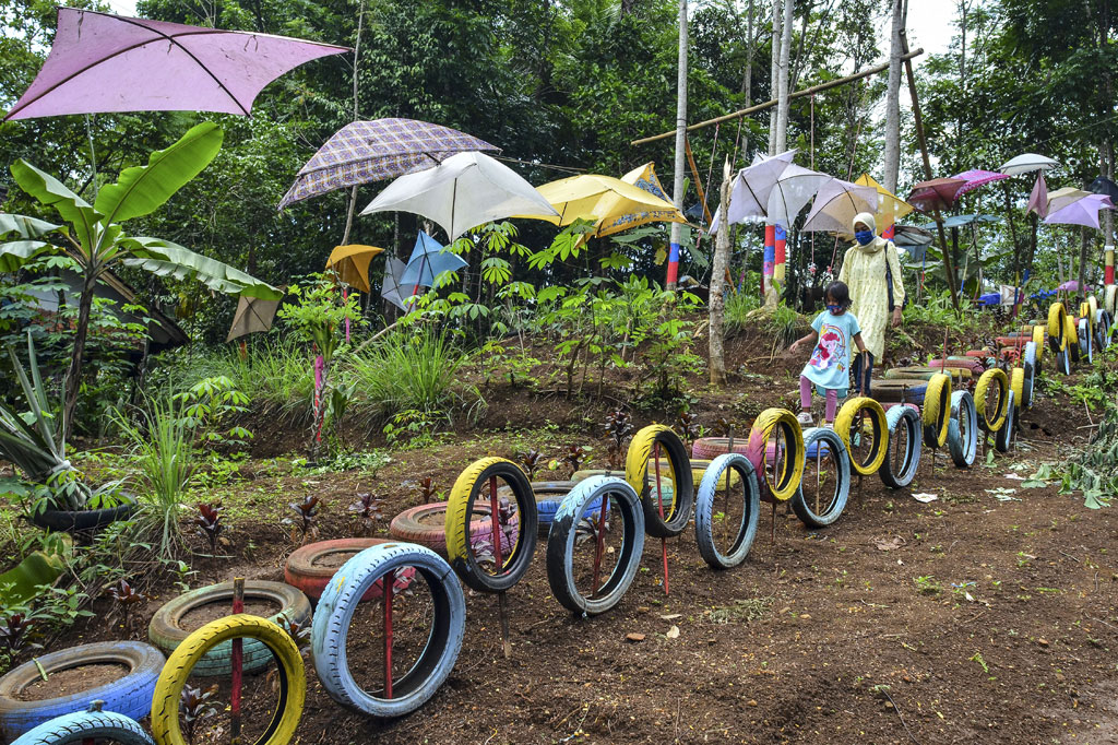 Pengunjung menikmati wahana permainan di Wisata Bukit Sinarmulya Bojongsari Desa Gegempalan, Kabupaten Ciamis, Jawa Barat, Sabtu, 31 Oktober 2020. Wisata Bukit Sinarmulya merupakan wisata edukasi dan religi dengan menyediakan wahana permainan tradisional berupa ayunan, perosotan, jungkitan, roller coaster dari bambu atau lori-lorian serta egrang, yang dikembangkan oleh Pemerintah Desa setempat. ANTARA FOTO/Adeng Bustomi