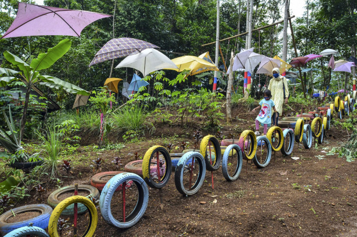 Pengunjung menikmati wahana permainan di Wisata Bukit Sinarmulya Bojongsari Desa Gegempalan, Kabupaten Ciamis, Jawa Barat, Sabtu, 31 Oktober 2020. Wisata Bukit Sinarmulya merupakan wisata edukasi dan religi dengan menyediakan wahana permainan tradisional berupa ayunan, perosotan, jungkitan, roller coaster dari bambu atau lori-lorian serta egrang, yang dikembangkan oleh Pemerintah Desa setempat. ANTARA FOTO/Adeng Bustomi