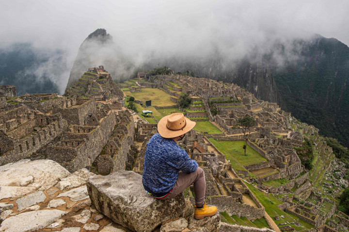 Seorang turis berpose untuk foto di depan situs wisata arkeologi Machu Picchu di Cusco, Peru, Minggu, 1 November 2020.