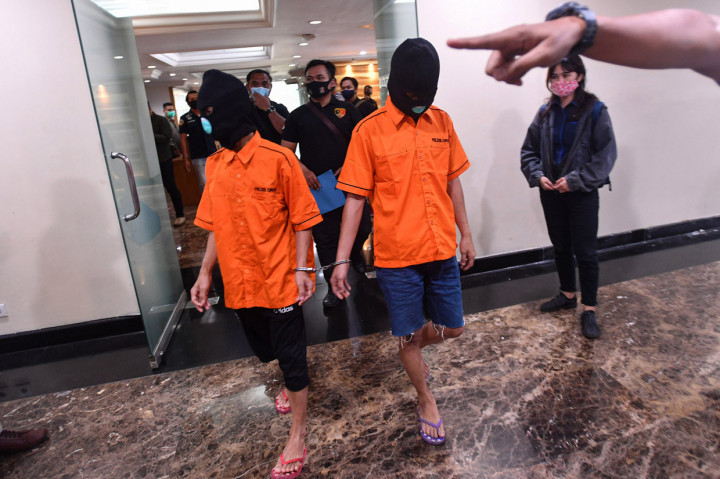 Dua tersangka kasus begal pesepeda digiring petugas saat rilis di Polda Metro Jaya, Jakarta.