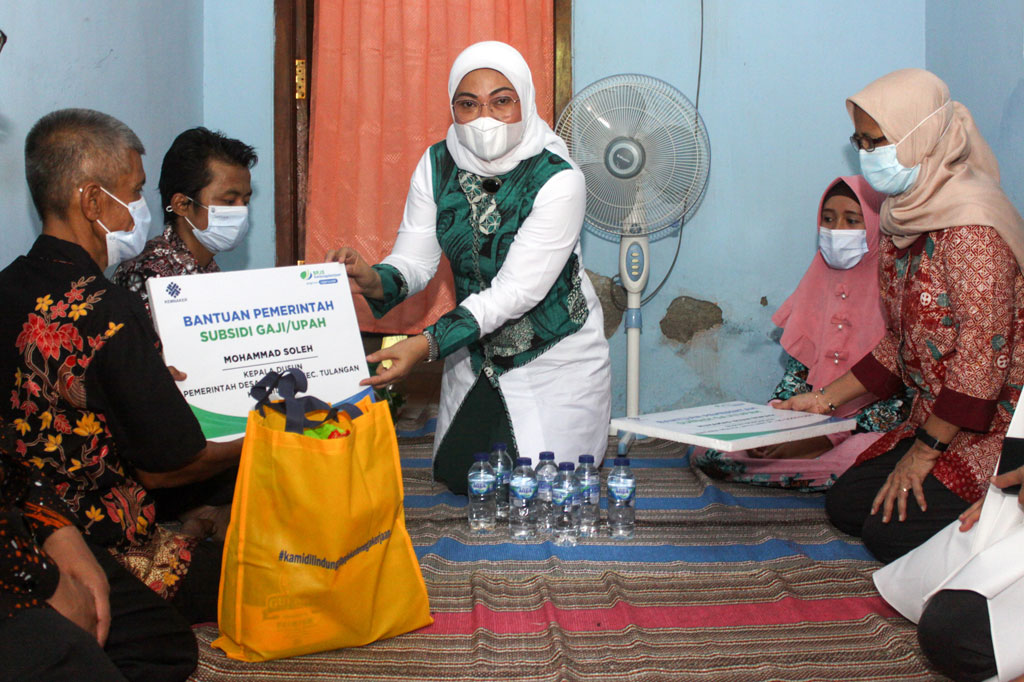Menteri Ketenagakerjaan Ida Fauziyah (tengah) menyerahkan bantuan kepada warga di Desa Grinting, Tulangan, Sidoarjo, Jawa Timur, Jumat, 6 November 2020.