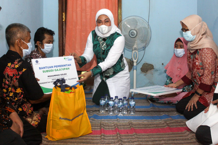 Menteri Ketenagakerjaan Ida Fauziyah (tengah) menyerahkan bantuan kepada warga di Desa Grinting, Tulangan, Sidoarjo, Jawa Timur, Jumat, 6 November 2020.