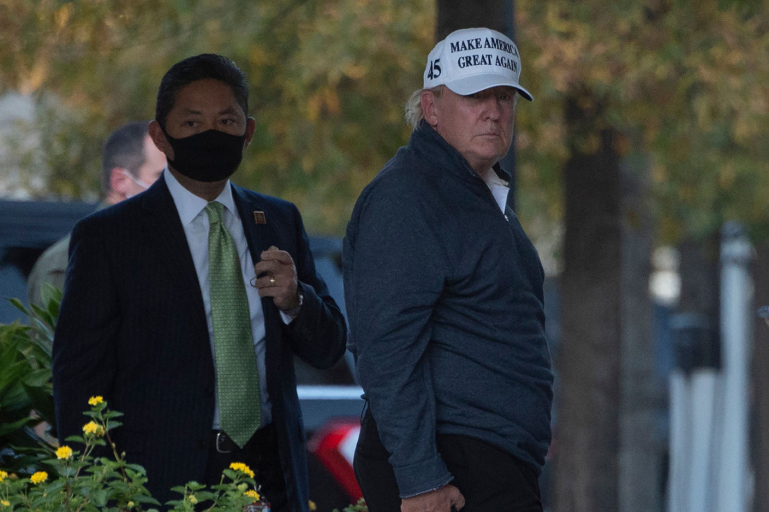 Dari foto yang diambil wartawan, Trump tiba di Gedung Putih dengan mengenakan jaket berwarna abu-abu dan topi putih bertuliskan 'Make America Great Again'.