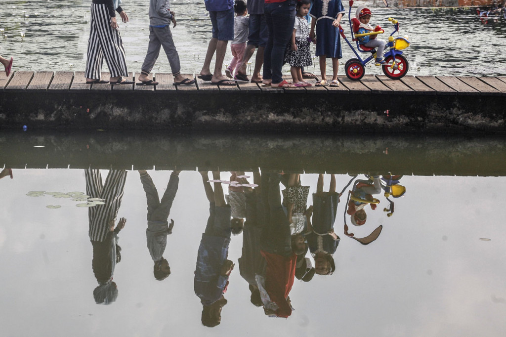 Sejumlah warga menikmati keindahan Danau Ecology Park (Ecopark) yang berada di kawasan Cibinong Science Center (CSC) atau Lembaga Ilmu Pengetahuan Indonesia (LIPI), Kebun Raya Cibinong, Kabupaten Bogor, Jawa Barat.

