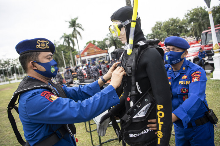 Anggota Ditpolairud Polda Sumsel merapikan perlengkepan menyelem saat mengikuti apel Kesiapsiagaan Antisipasi Bencana Alam di Lapangan Griya Agung Palembang, Sumatera Selatan.
