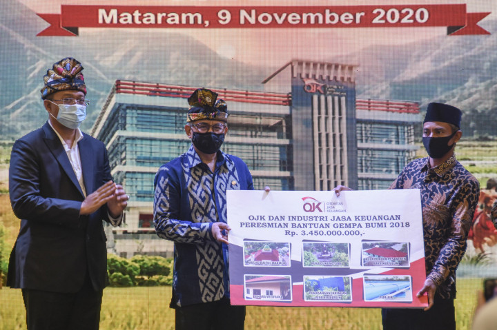 Ketua Dewan Komisioner Otoritas Jasa Keuangan (DK OJK) Wimboh Santoso (tengah) bersama Gubernur NTB Zulkieflimansyah (kiri) memberikan bantuan secara simbolis saat acara peresmian kantor Otoritas Jasa Keuangan (OJK) NTB di Mataram.