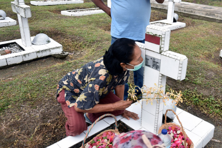 Seorang penziarah mencium nisan keluarganya di Taman Makam Pahlawan Kusuma Dharma, Kota Pekanbaru, Riau. Tidak ada upacara khusus yang melibatkan banyak orang dalam peringatan Hari Pahlawan tahun ini di Kota Pekanbaru karena pandemi covid-19. ANTARA FOTO/FB Anggoro
