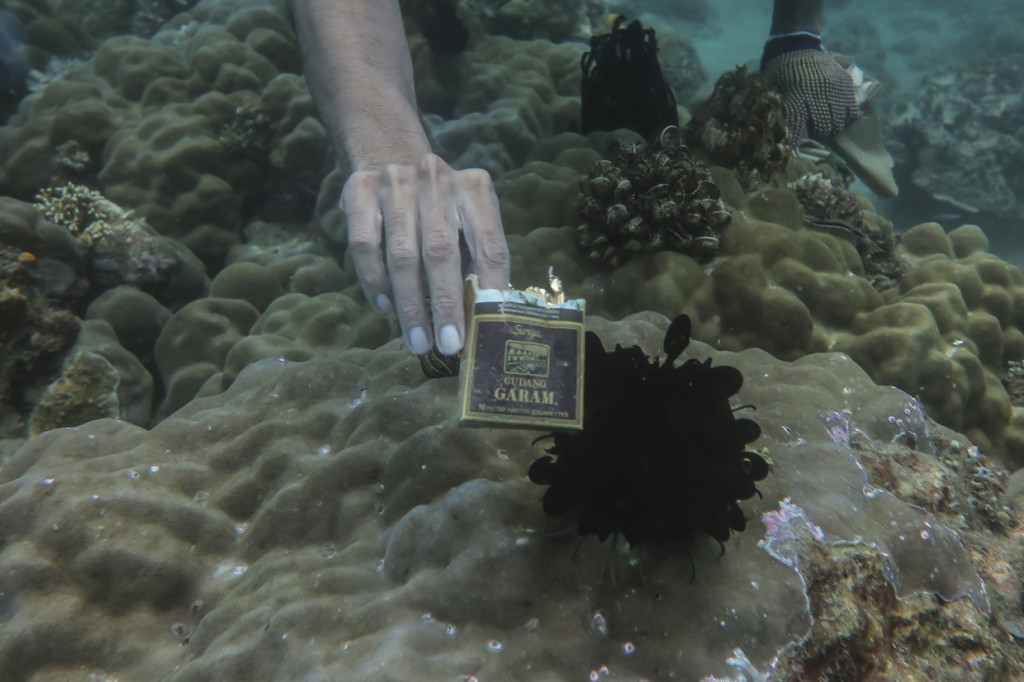 Penyelam dari komunitas Tunas Bahari Maluku menunjukan sampah plastik di perairan Pulau Haruku, Maluku.