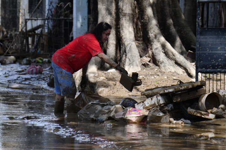 Warga membersihkan sampah dan lumpur yang terbawa banjir bandang setelah Topan Vamco menerjang wilayah Marikino City, pinggiran Kota Manila, Filipina, Jumat, 13 November 2020.