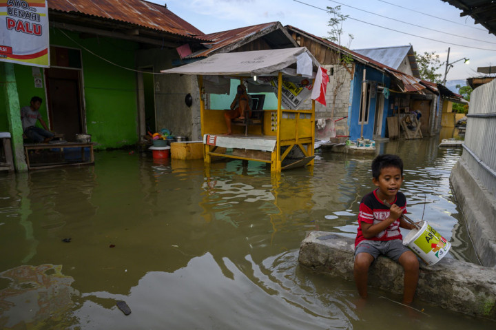 Warga beraktivitas di rumahnya yang digenangi air akibat banjir rob di Kampung Lere, Kecamatan Palu Barat, Palu, Sulawesi Tengah, Sabtu, 14 November 2020. 