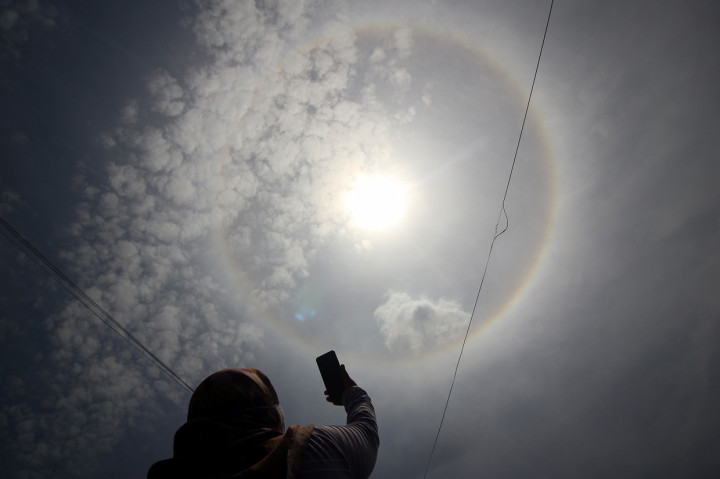 Warga menyaksikan fenomena halo matahari di Surabaya, Jawa Timur.