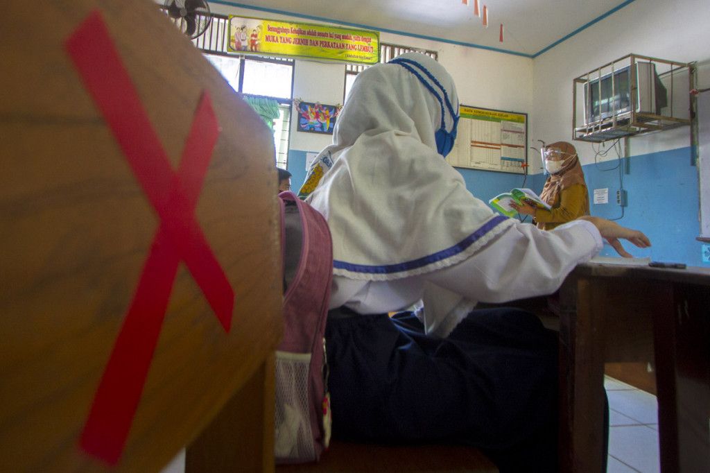 Seorang guru memberikan pelajaran kepada siswa saat simulasi belajar tatap muka di SMP Negeri 7 Banjarmasin, Kalimantan Selatan.