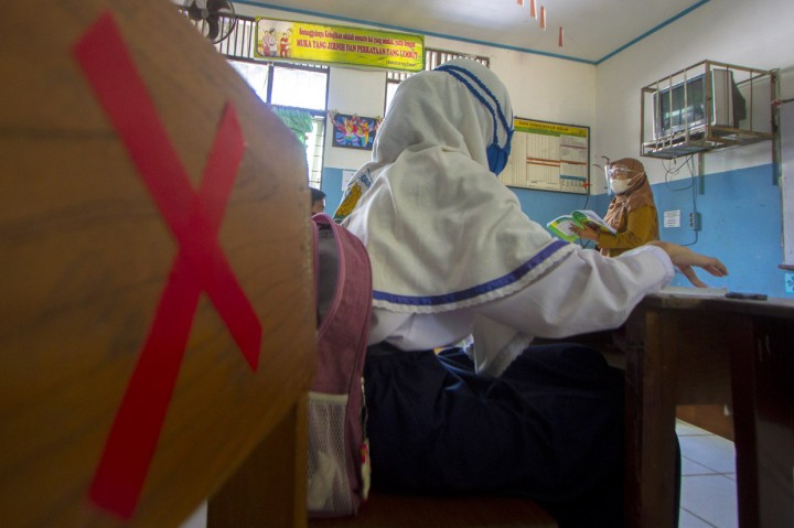 Seorang guru memberikan pelajaran kepada siswa saat simulasi belajar tatap muka di SMP Negeri 7 Banjarmasin, Kalimantan Selatan.