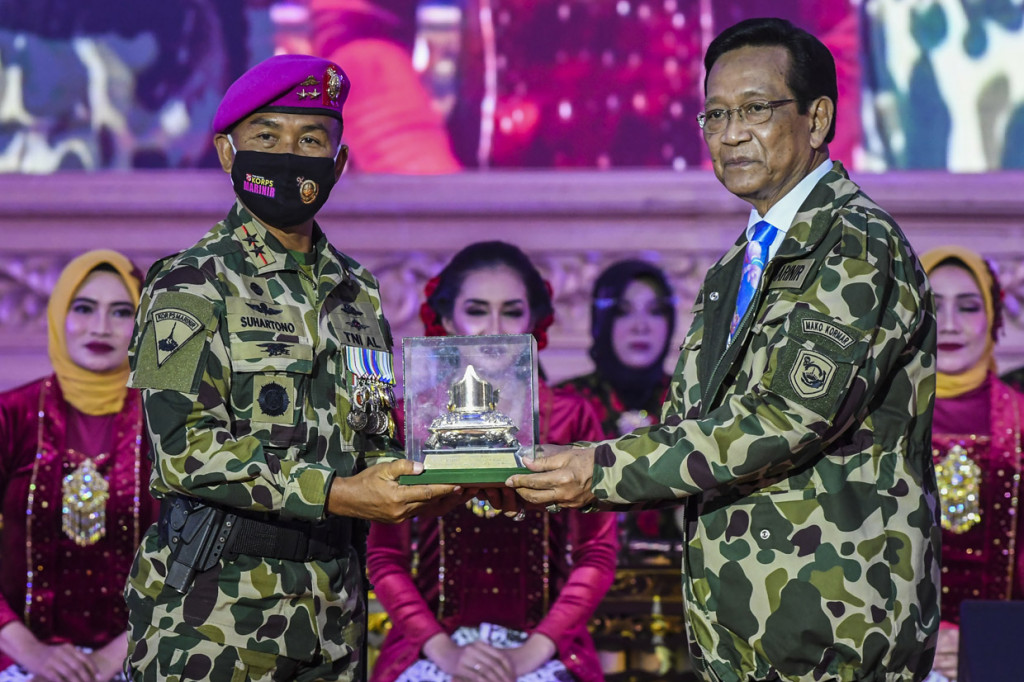 Komandan Korps Marinir (Dankormar) Mayor Jendral TNI (Mar) Suhartono (kiri) menerima cinderamata Gending Gati Marinir dari Gubernur Daerah Istimewa Yogyakarta Sri Sultan Hamengkubuwana X (kanan) usai upacara HUT ke-75 Korps Marinir TNI Angkatan Laut (AL) di Markas Komando Korps Marinir, Jalan Prajurit KKO Usman dan Harun, Jakarta.
