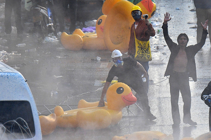 Demo yang berlangsung di sekitar Gedung Parlemen tersebut berujung ricuh. Para pendemo itu terlibat bentrok dengan polisi yang berjaga di depan Gedung Parlemen Thailand. Polisi bahkan sampai menembakkan gas air mata dan water cannon. AFP Photo/Mladen Antonov 