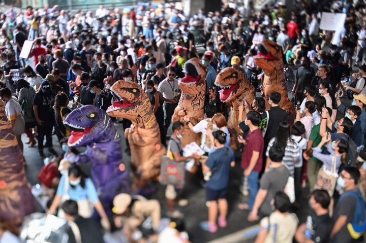 Ribuan siswa sekolah menengah yang kesal dengan sistem pendidikan Thailand kembali turun ke jalan bersama para pengunjuk rasa yang berpakaian seperti penari dinosaurus di Bangkok pada Sabtu, 21 November 2020.