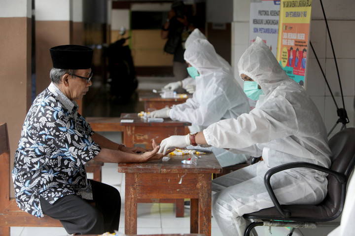 Warga Petamburan diambil sampel darah nya saat mengikuti rapid tes di SDN 01 Petamburan, Jakarta Pusat.