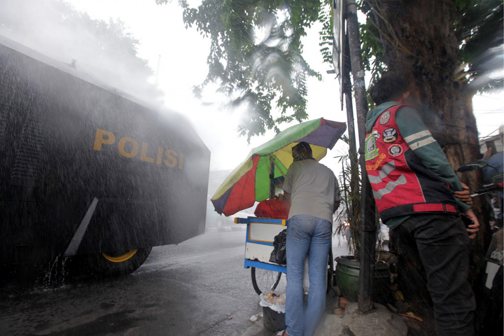 Kendaraan water canon Brimob Polda Metro Jaya menyemprot cairan disinfektan di sepanjang jalan kawasan Petamburan, Jakarta Pusat, Jakarta.