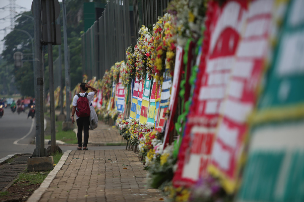 Puluhan karangan bunga dari berbagai elemen masyarakat berjejer menghiasi pagar Kodam Jaya, dari ujung utara hingga selatan.
