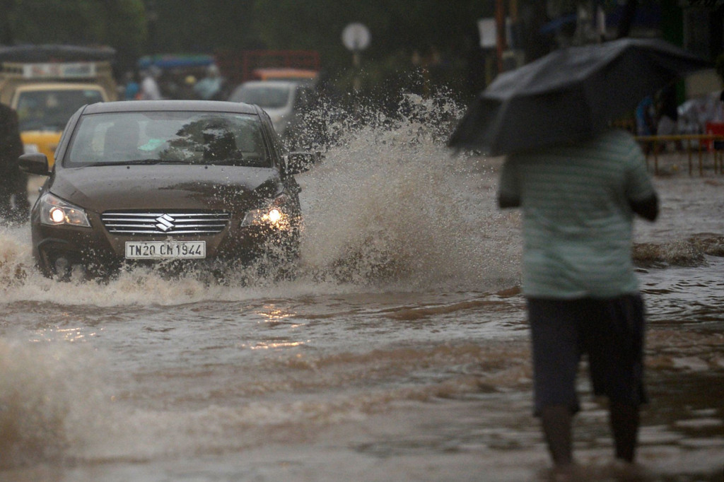 Orang-orang mengungsi melewati air banjir setinggi lutut di beberapa jalan di selatan Chennai, dengan topografi dataran rendah daerah tersebut sangat rentan terhadap banjir.