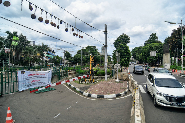 Kendaraan melintas di dekat pembatas di perlintasan kereta di Jalan Tentara Pelajar, Jakarta, Minggu, 29 November 2020.
