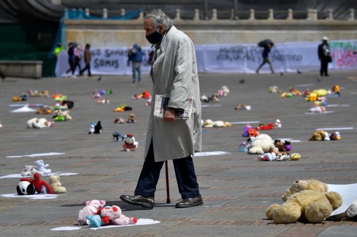 Seorang pria berjalan di hamparan mainan lucu yang ditempatkan di alun-alun Bolivar selama demonstrasi menentang pelecehan anak di Bogota, Kolombia.