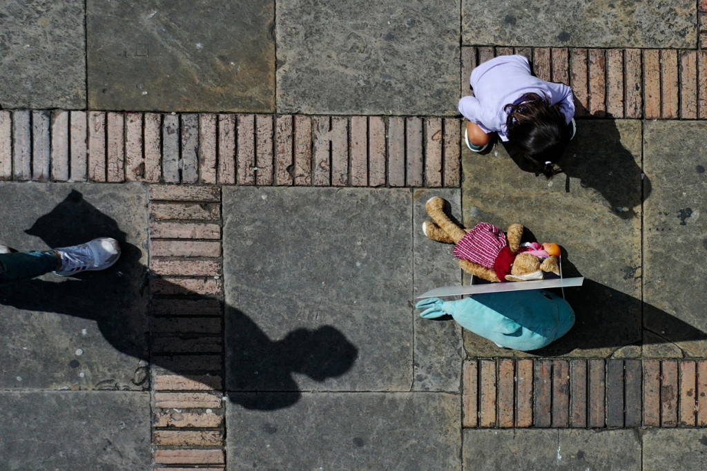 Seorang anak perempuan melihat mainan lucu yang ditempatkan di alun-alun Bolivar, Bogota, dalam aksi menentang pelecehan anak.
