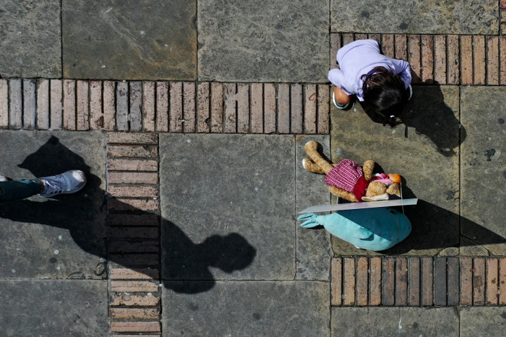 Seorang anak perempuan melihat mainan lucu yang ditempatkan di alun-alun Bolivar, Bogota, dalam aksi menentang pelecehan anak.

