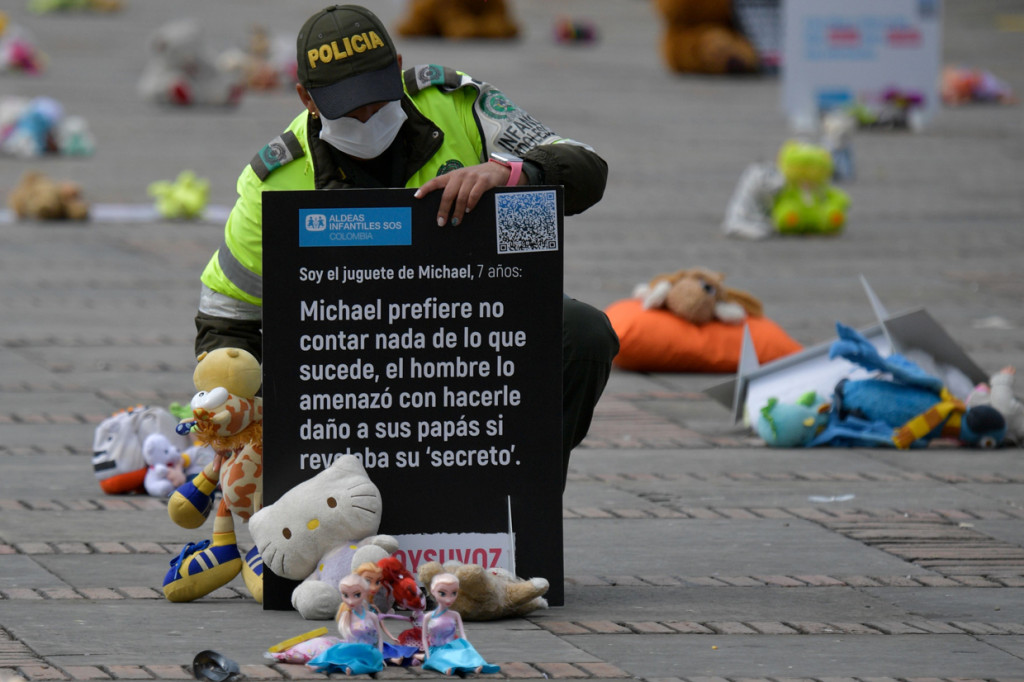 Petugas polisi membantu meletakkan pesan di antara boneka lucu dalam dalam aksi menentang pelecehan anak di alun-alun Bolivar, Bogota, Kolombia.