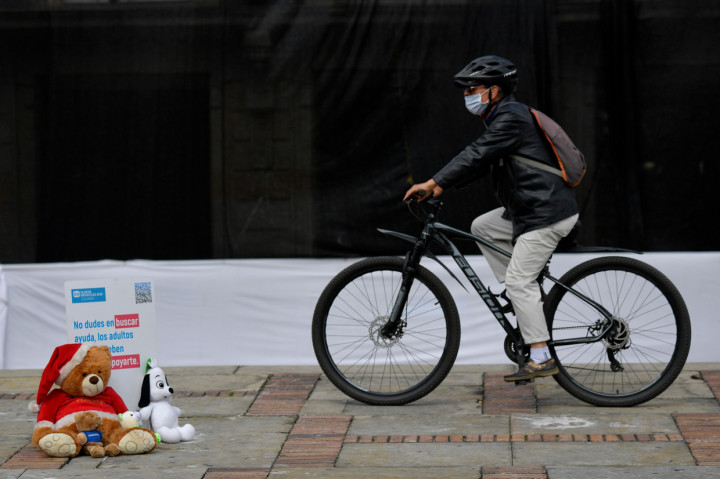 Pesepeda melintas di dekat boneka lucu yang ditempatkan di alun-alun Bolivar selama demonstrasi menentang pelecehan seksual pada anak di Bogota, Kolombia.