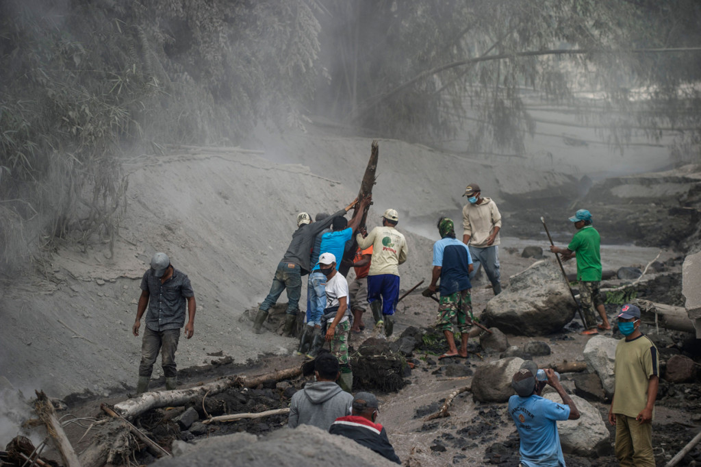 Warga mencoba membuat akses lahar panas erupsi Gunung Semeru di kawasan Besuk Kobokan, Pronojiwo, Lumajang, Jawa Timur.