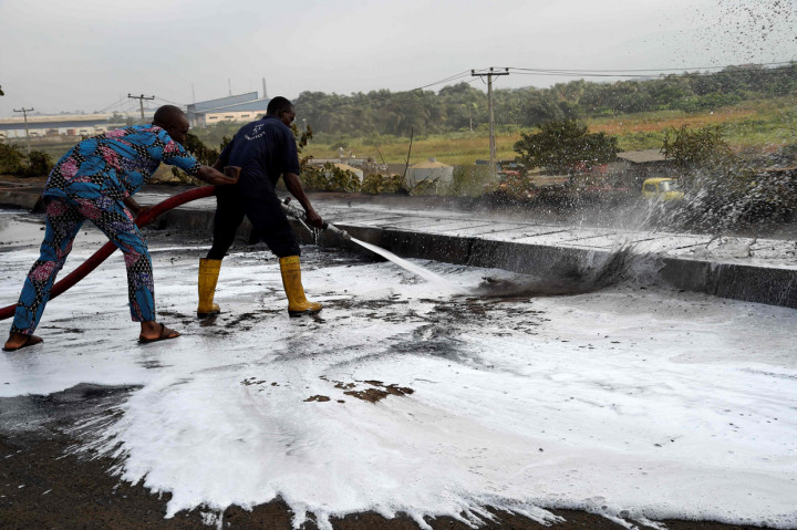 Petugas pemadam kebakaran membersihkan jalan setelah sebuah kapal tanker berisi bensin jatuh dan terbakar di jalan tol Lagos-Ibadan, di Magboro.