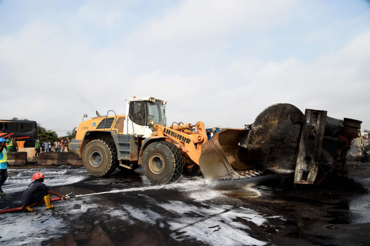 Alat berat mengevakuasi sisa-sisa kebakaran kapal tanker berisi bensin yang jatuh dan terbakar di jalan tol Lagos-Ibadan, di Magboro.