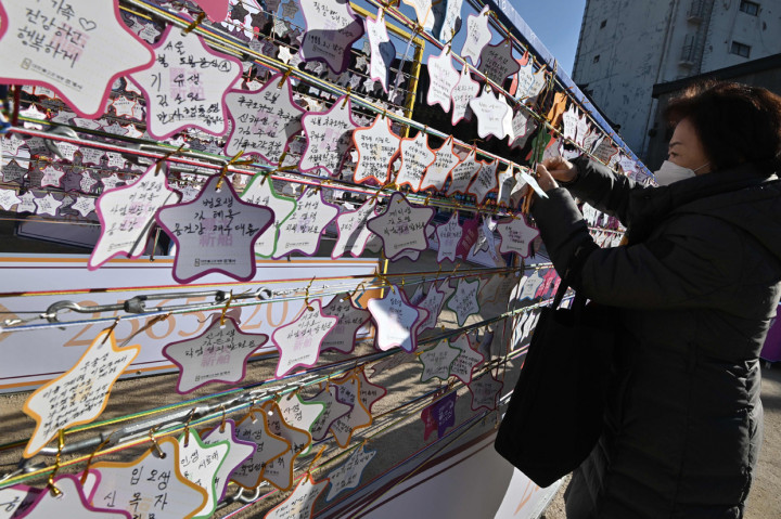 Seorang ibu menggantungkan kertas berisi doa keberhasilan untuk anaknya dalam ujian masuk perguruan tinggi di Kuil Buddha Jogyesa, Seoul Korea Selatan.