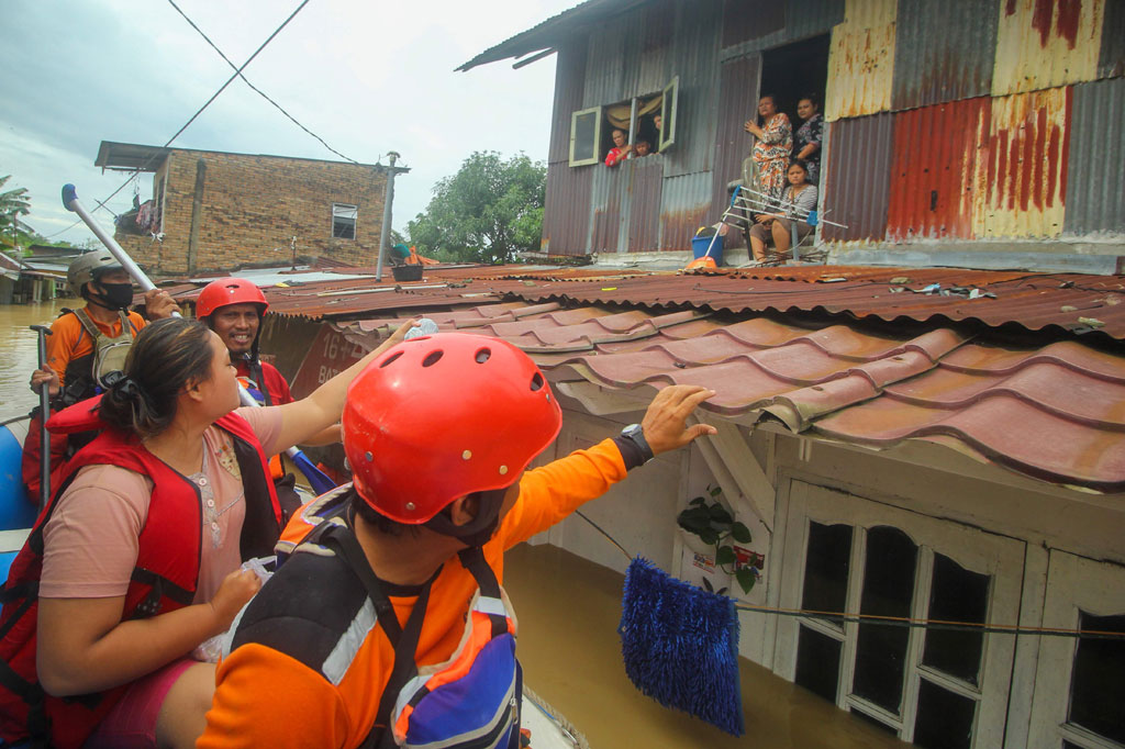 Warga korban banjir menunggu proses evakuasi dari lantai dua rumah mereka di Desa Tanjung Selamat, Kecamatan Sunggal, Deliserdang, Sumatera Utara, Jumat, 4 Desember 2020.