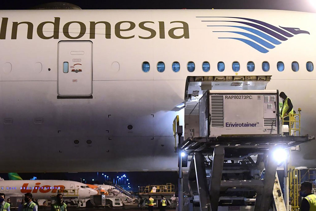 Petugas menurunkan kontainer berisi vaksin covidd-19 saat tiba di Bandara Soekarno-Hatta, tangerang, Banten, Minggu, 6 Desember 2020 malam.