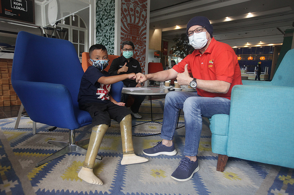 Ketua Yayasan Kick Andy, Andy Noya (kanan) bersama penerima program kaki palsu Muhammad Attar berbincang di Kantor Pusat Angkasa Pura II , Tangerang, Banten.