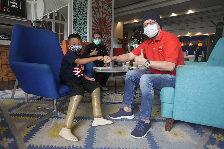 Ketua Yayasan Kick Andy, Andy Noya (kanan) bersama penerima program kaki palsu Muhammad Attar berbincang di Kantor Pusat Angkasa Pura II , Tangerang, Banten.