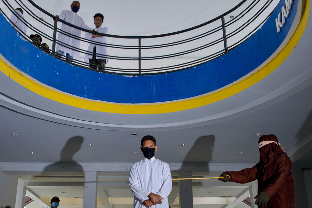 Algojo melakukan eksekusi hukuman cambuk terhadap salah satu pelanggar syariah di Taman Bustanussalatin, Banda Aceh, Aceh, Senin, 7 Desember 2020.