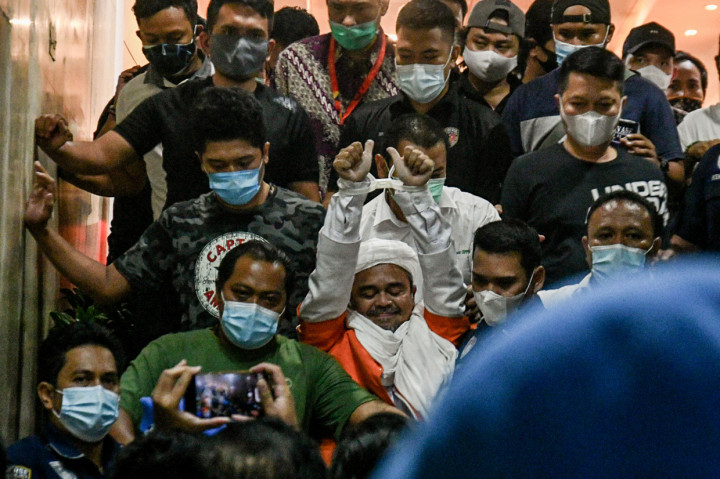 Imam Besar FPI Habib Rizieq Shihab keluar dari gedung pemeriksaan di Ditreskrimum Polda Metro Jaya, Minggu, 13 Desember 2020, dini hari WIB. Rizieq keluar menggunakan rompi tahanan dengan tangan diborgol kabel ties dan langsung memasuki sebuah kendaraan yang telah disiapkan kepolisian.