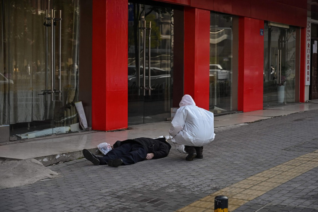 Seorang pria meninggal dan terbaring di trotoar di jalanan Kota Wuhan, Tiongkok, Kamis, 30 Januari 2020. Belum diketahui penyebab kematiannya. AFP PHOTO/Hector Retamal